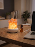 USB salt glow lamp on a desk, its white cable plugged into a laptop USB port, essential oil bottle beside it