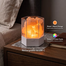 The lamp lit warm orange on a bedside table beside a note of its two light modes: press the button once for the warm orange glow, press it again for a cycle through seven colours, and recharge it over USB-C