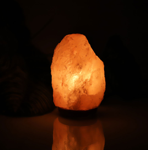 Natural Himalayan pink salt lamp with a hand-carved crystal glowing warm amber
