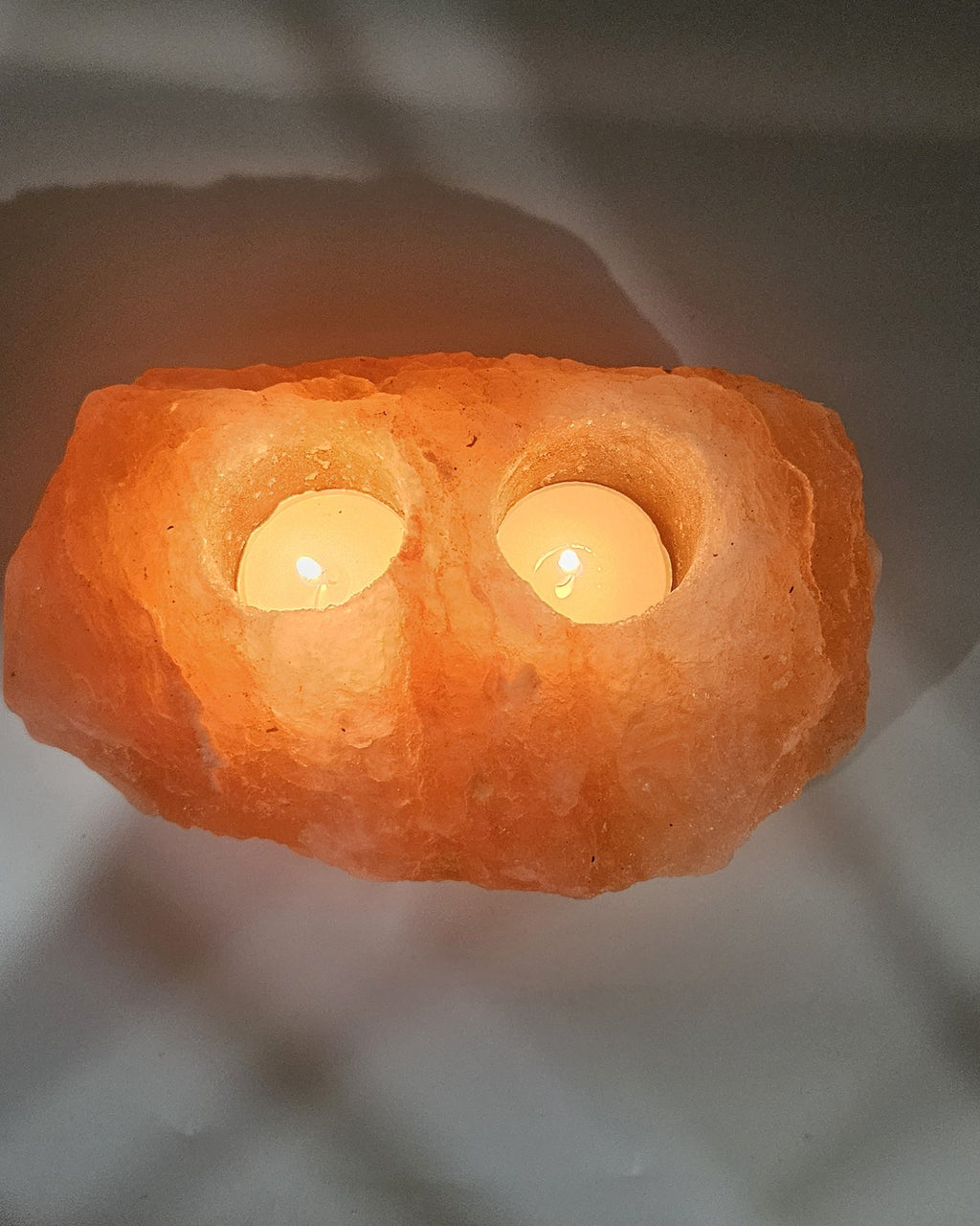 Himalayan salt candle holder with two tea light wells, both lit