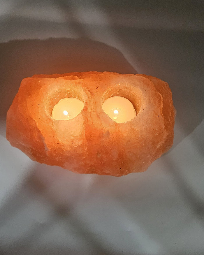 Two well salt candle holder lit, glowing through the stone