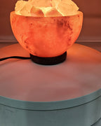 Himalayan salt bowl lamp lit, filled with loose salt chunks