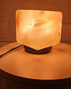 Himalayan salt cube lamp lit at an angle