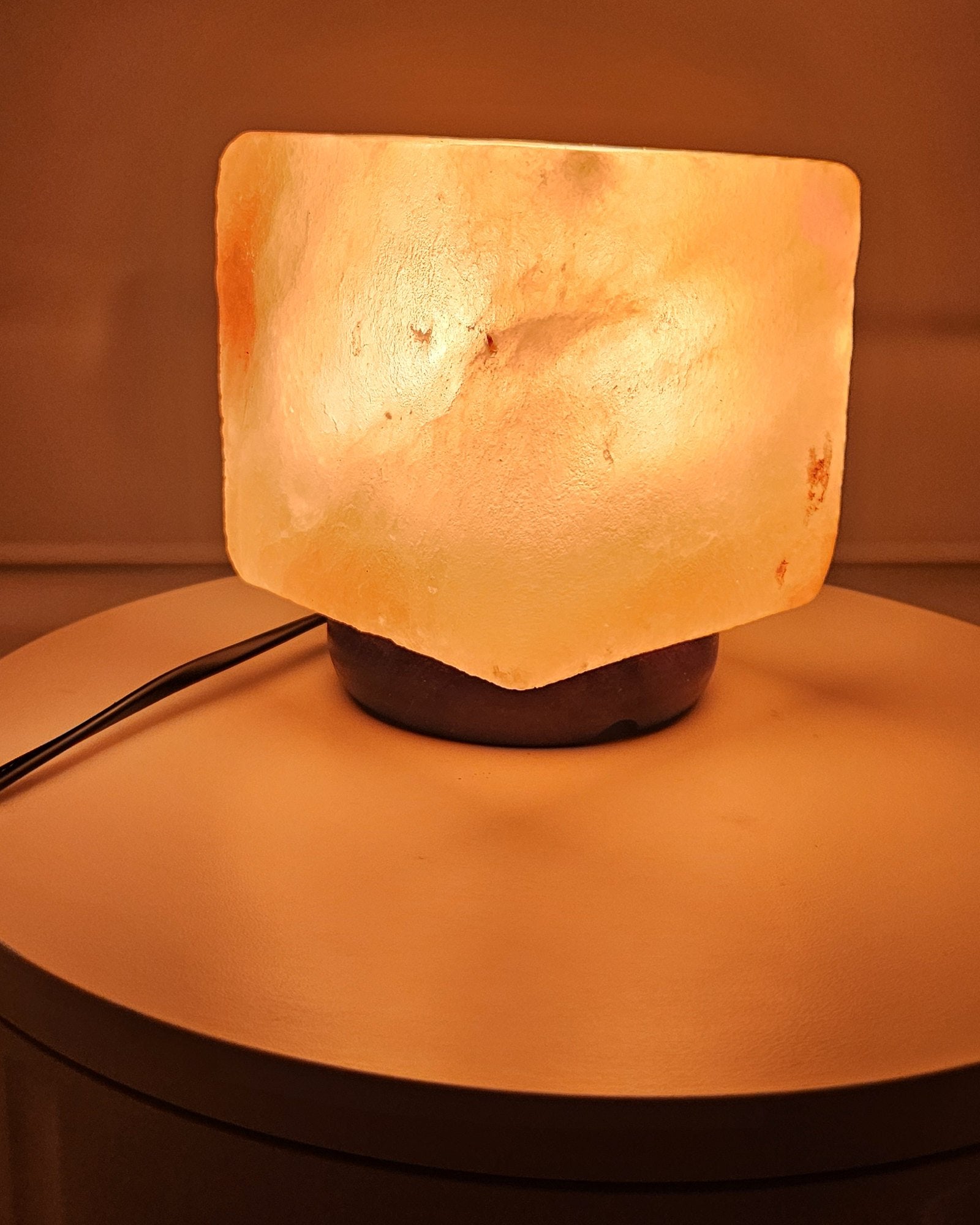 Himalayan salt cube lamp lit at an angle