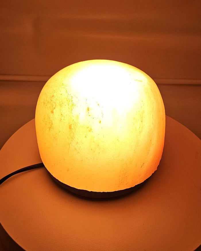 Himalayan salt dome lamp lit, warm glow through the salt