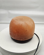 Himalayan salt dome lamp in daylight with the cord visible