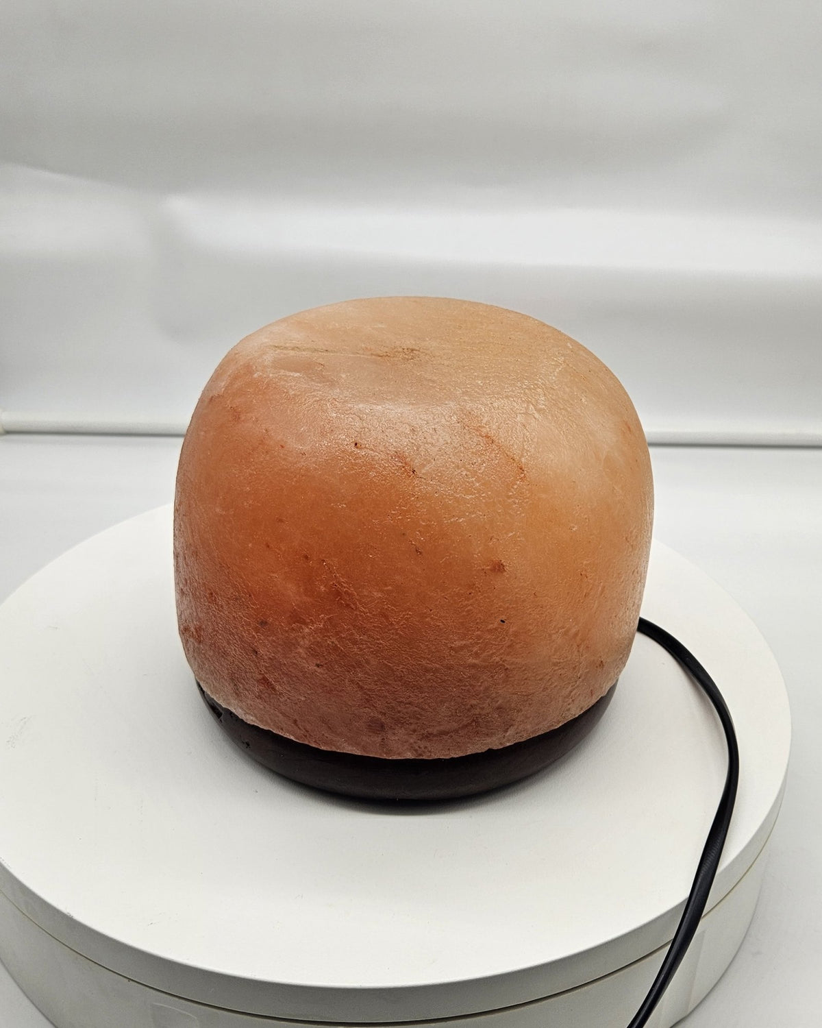 Himalayan salt dome lamp in daylight with the cord visible