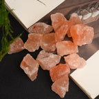 Rough orange salt stones in mixed sizes arranged on an open book