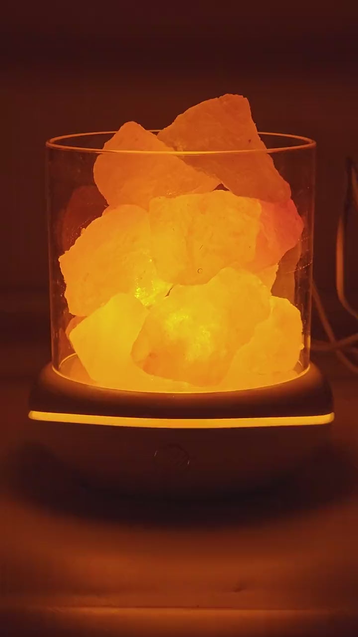 The salt glow lamp glowing warm amber on a desk