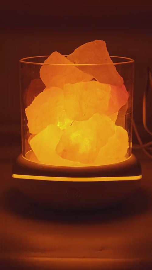 The salt glow lamp glowing warm amber on a desk