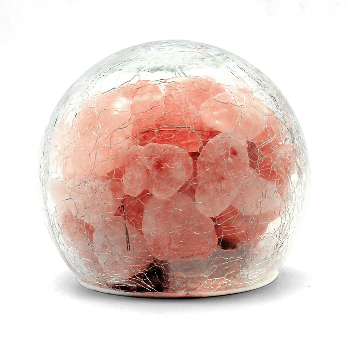 Battery powered mini Himalayan salt lamp unlit on a white background: rough pink salt pieces sealed inside a clear crackle finish glass globe on a white base