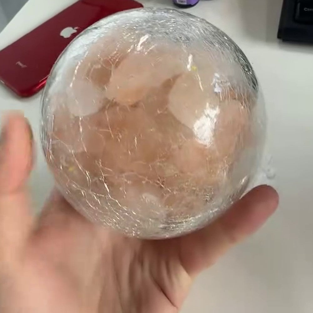 The mini salt lamp held in one hand, showing it is small enough to sit in a palm
