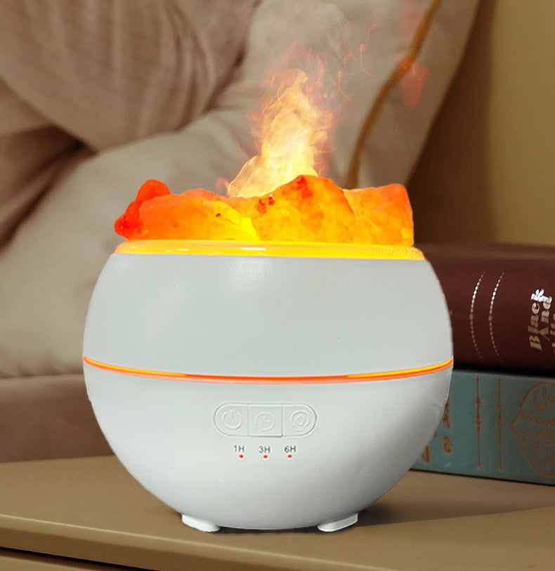 The humidifier running, an orange lit mist plume rising from the centre through the salt pieces, with the power and timer buttons and 1H 3H 6H markings on the base