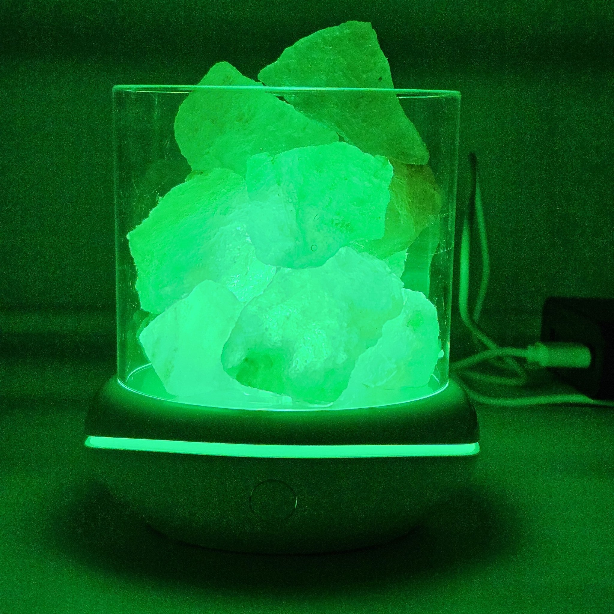 Himalayan salt glow lamp in green colour mode, USB cable and lit base ring visible