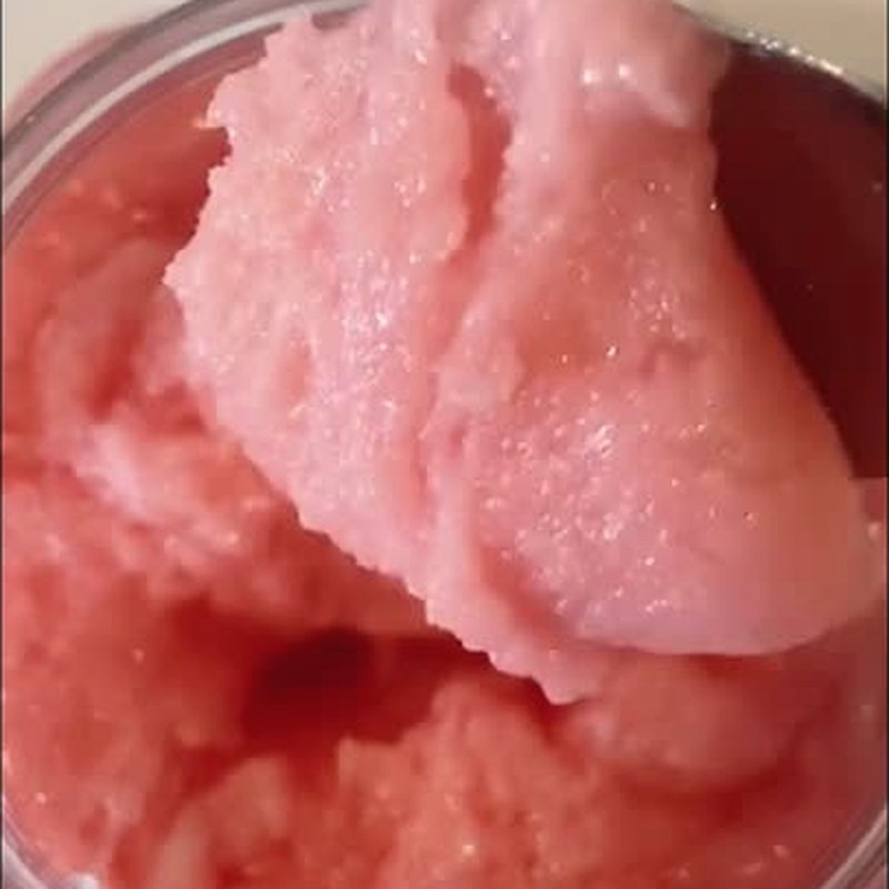 Close-up of the real pink Himalayan salt scrub texture inside the open jar, glistening salt crystals in a cream base