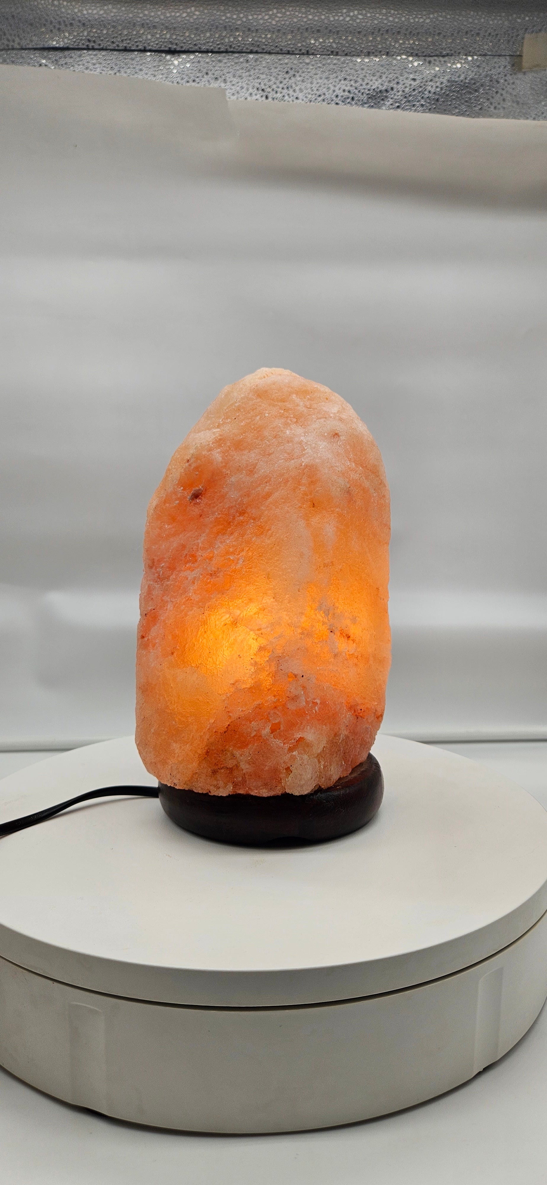 The real lamp lit warm on a white table, customer-style photo