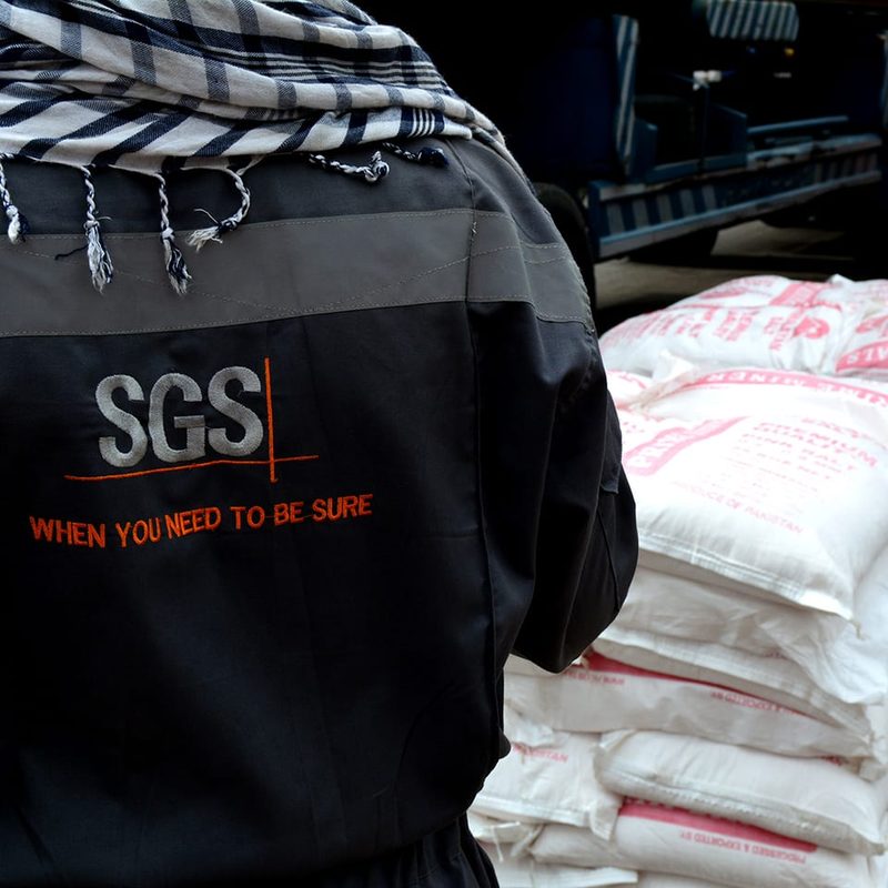 An independent inspector checking sacks of Himalayan salt labeled Product of Pakistan