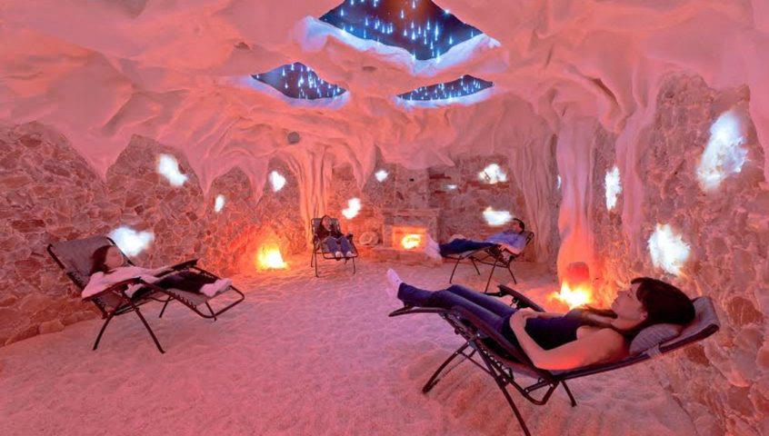 A warmly lit salt therapy room with walls of glowing Himalayan salt