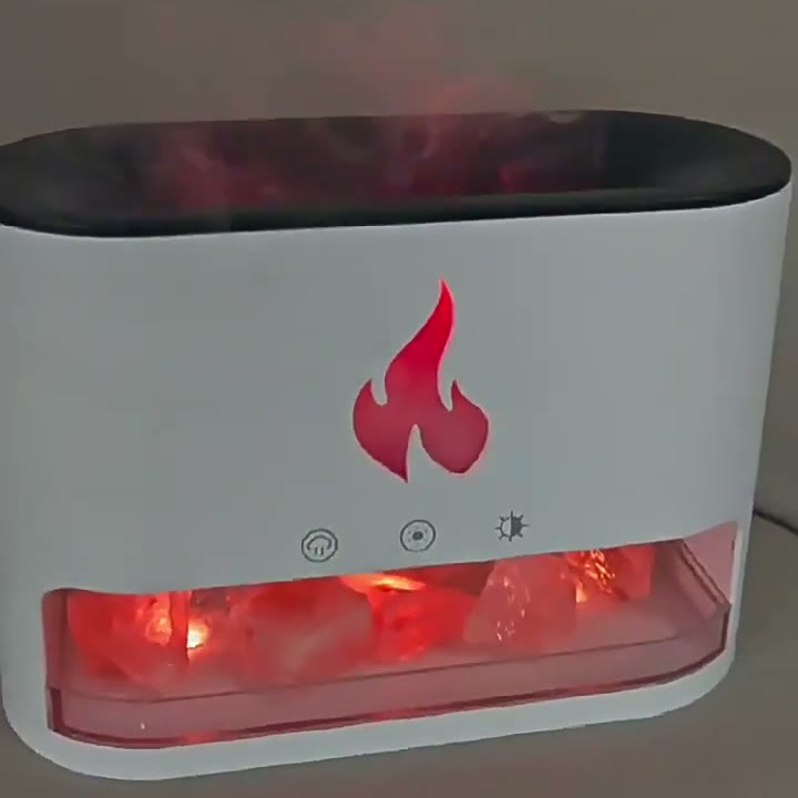 Close studio view of the diffuser, flame-effect glow and fine mist rising over the salt tray