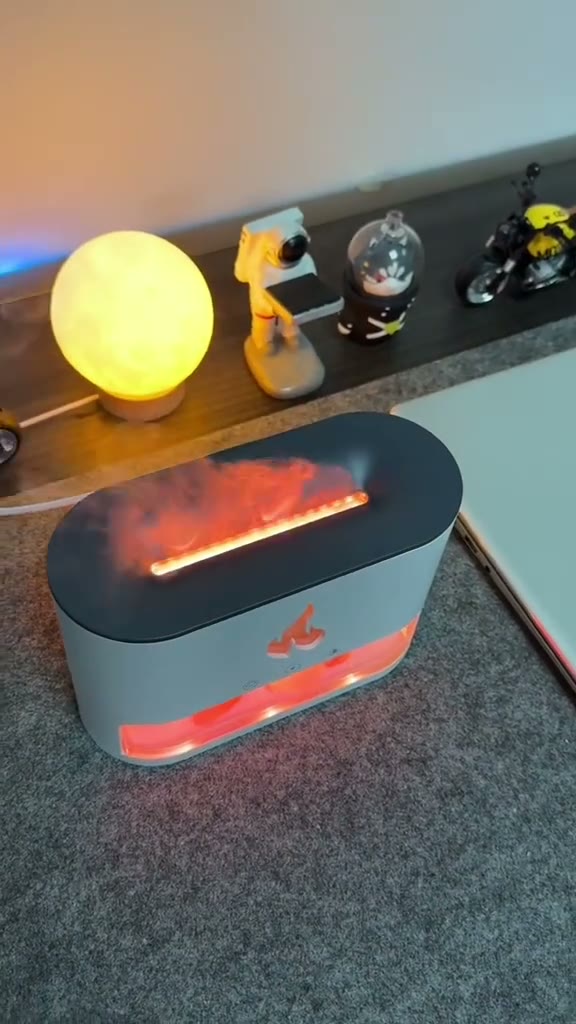The flame diffuser glowing warm amber with cool mist rising, on a shelf at dusk