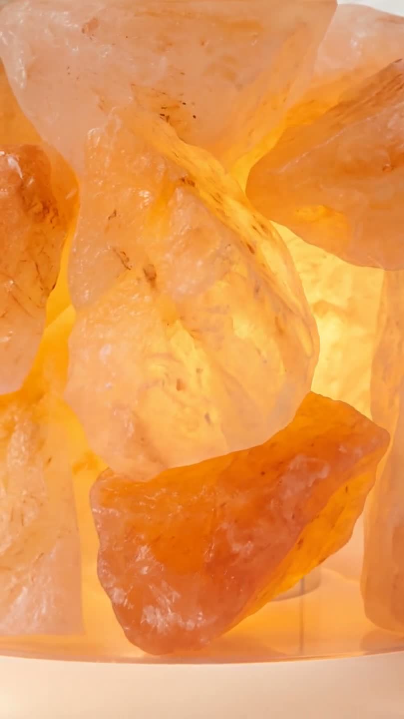 Close-up of a lit Himalayan salt lamp crystal showing uneven rose and amber colour with pale veining