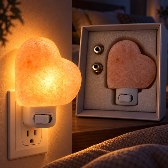 Heart Himalayan Salt Lamp glowing in a wall socket beside its unlit gift box at night.